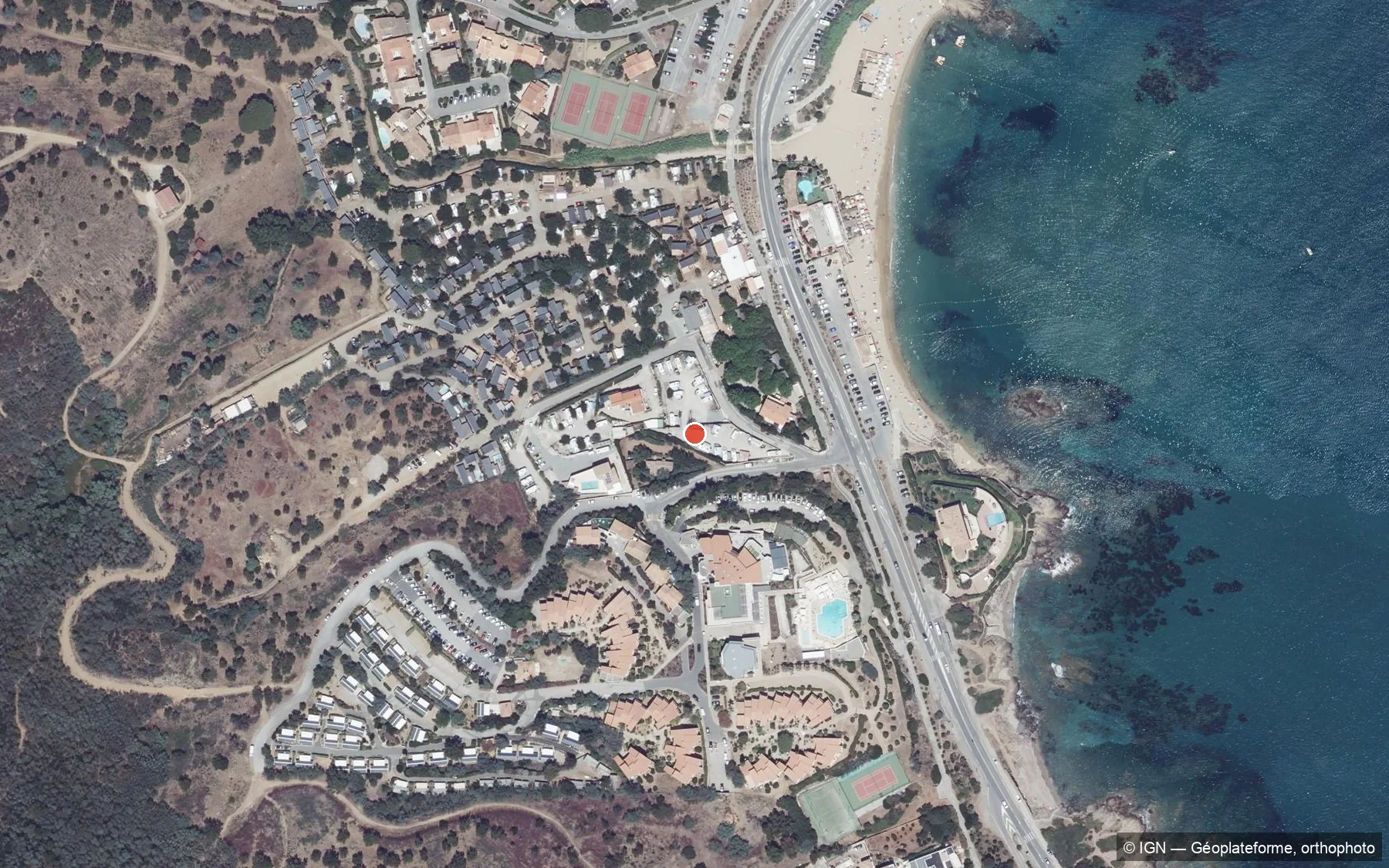 Vue aérienne de l'aire de camping-car Chez Marcel à La Gaillarde (Les Issambres) : les emplacements, le camping Au Paradis des Campeurs, la RD559, la plage de la Gaillarde et la Méditerranée